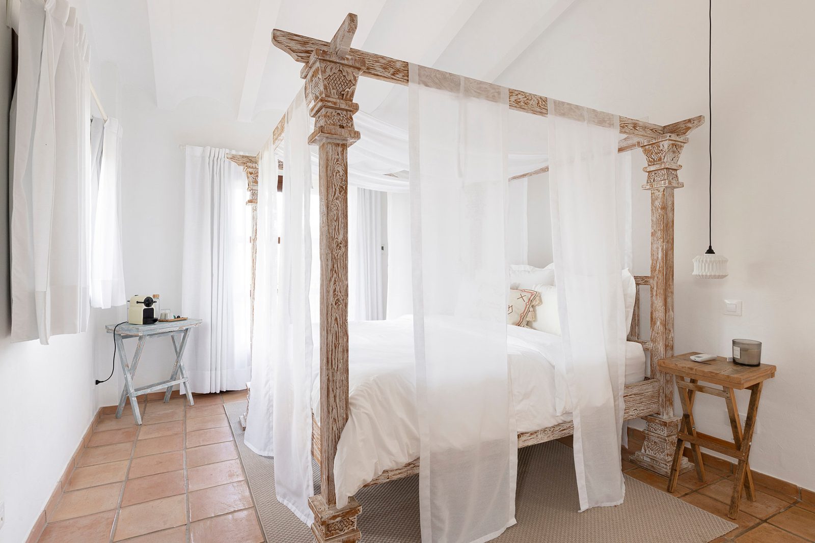 White bedroom with carved four-poster canopy bed