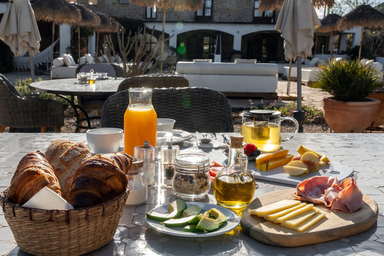 Breakfast spread of pastries, fruit and juice outdoors