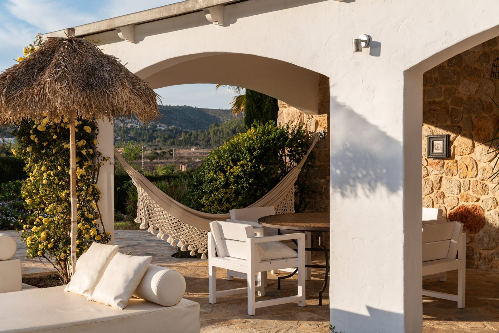 Hammock strung under a thatched terrace overlooking the valley