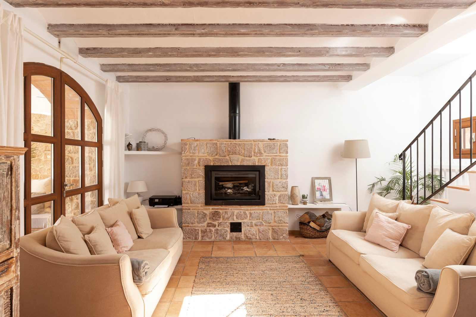 Bright living room with beamed ceiling, fireplace and deep sofas